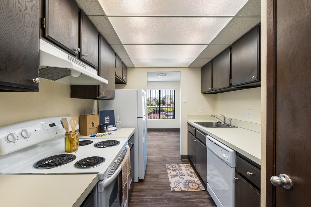 kitchen with dark wood cabinets and open to dining with window at Castlerock, Washington