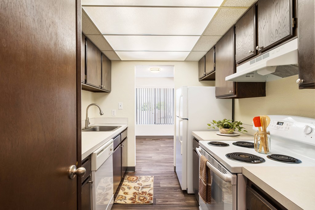 kitchen with dark wood cabinets and open to dining with window at Castlerock, Washington, 98801