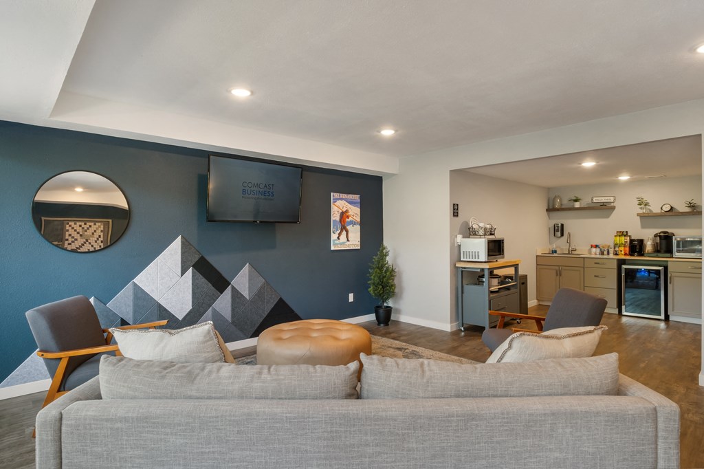 a living room with a couch and a chair in front of a wall with a tv on at Castlerock, Wenatchee Washington