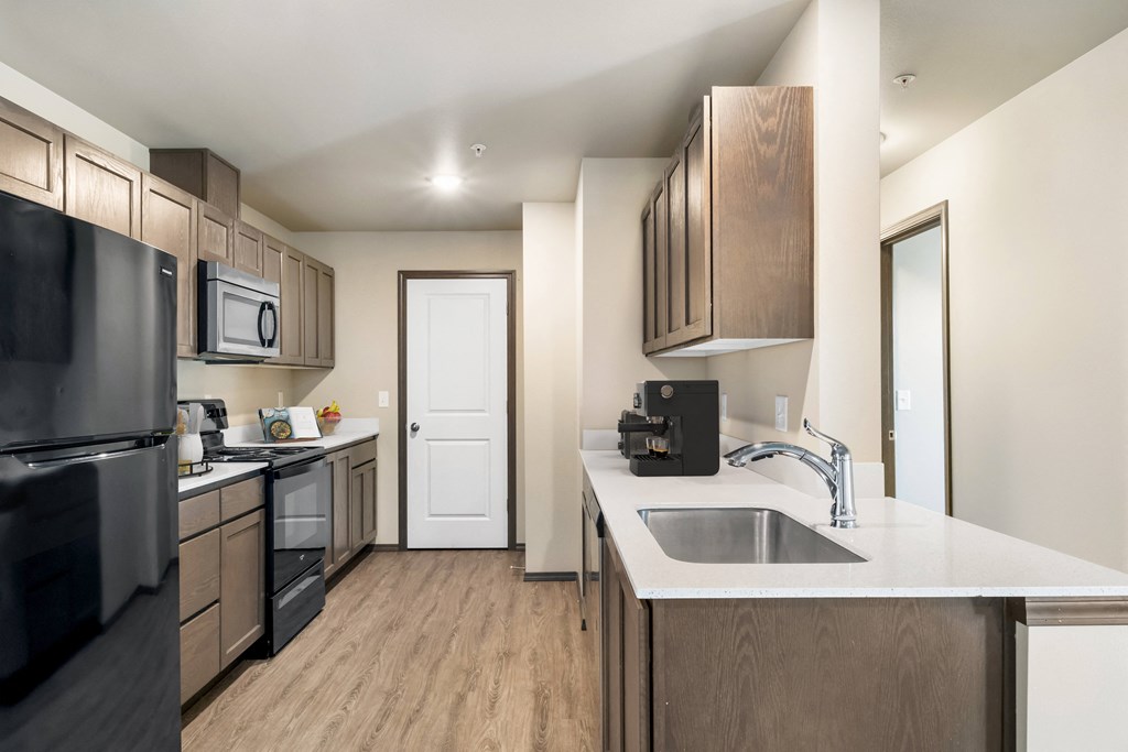 a kitchen with wooden cabinets and a white counter top a kitchen with wooden cabinets and a white counter top at Altitude, East Wenatchee, WA