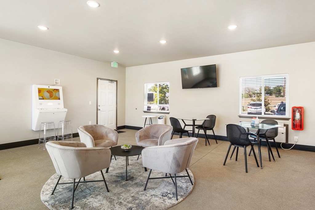 a room with chairs and a table with a television on the wall  at Altitude, East Wenatchee, WA