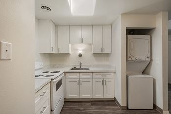 a kitchen with white cabinets and white appliances and a washer and dryer at Park View Apartments, Wenatchee Washington