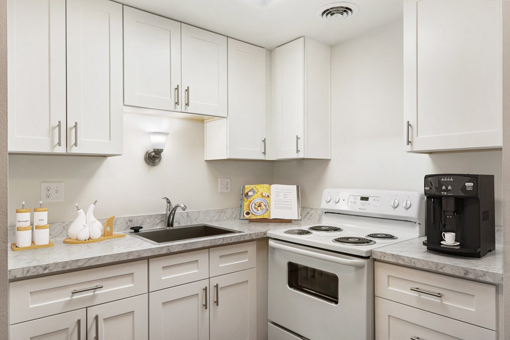 a kitchen with white cabinets and white appliances a kitchen with white cabinets and white appliances at Park View Apartments, Wenatchee