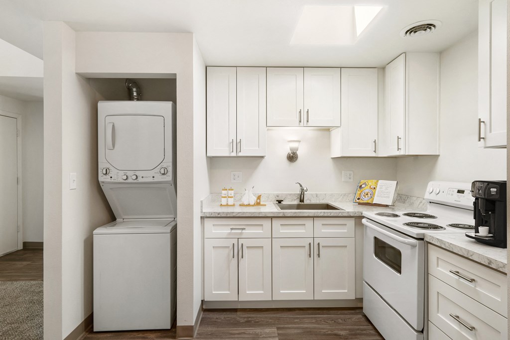 a kitchen with white cabinets and a white washer and dryer at Park View Apartments, Wenatchee, WA 98801