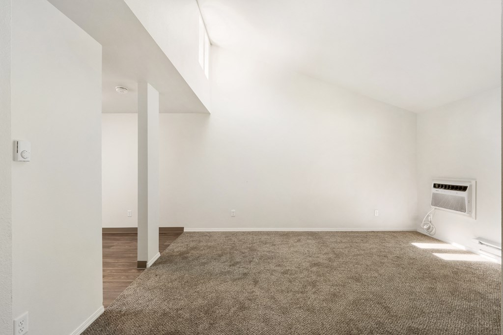 an empty living room with white walls and a carpet at Park View Apartments, Wenatchee, 98801