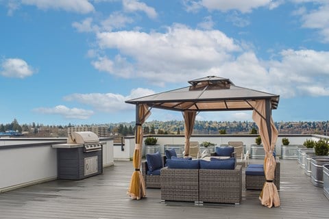 a rooftop terrace with a gazebo and couches on a roof