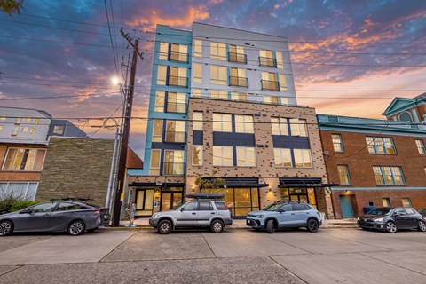 A modern building with cars parked in front.