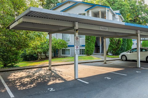 A parking lot with a car parked under a shelter.