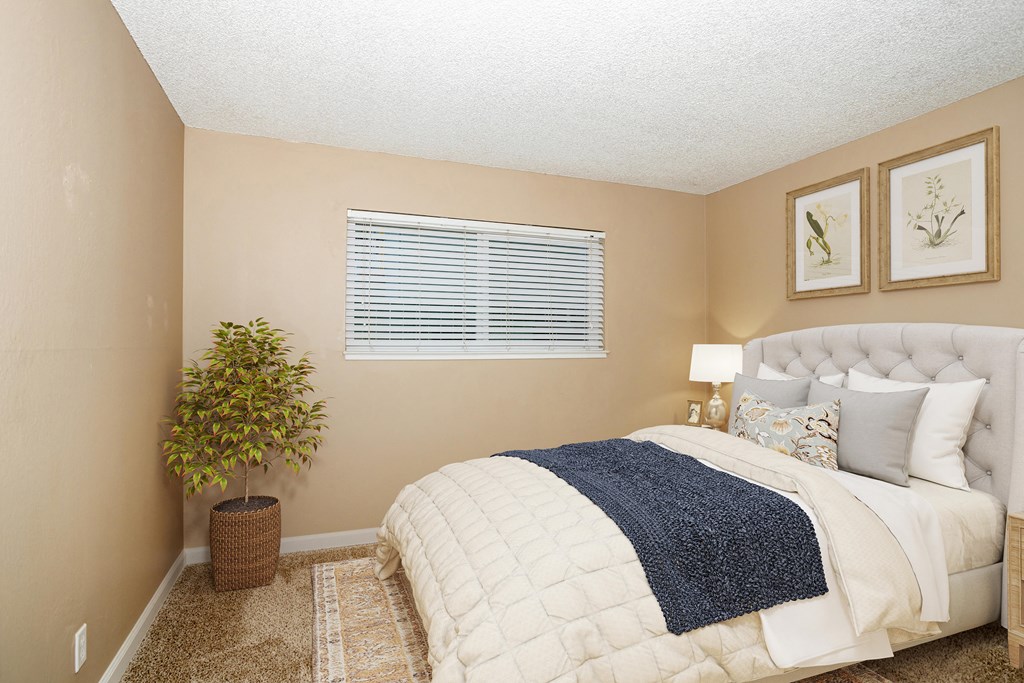 a bedroom with a bed and a potted plant