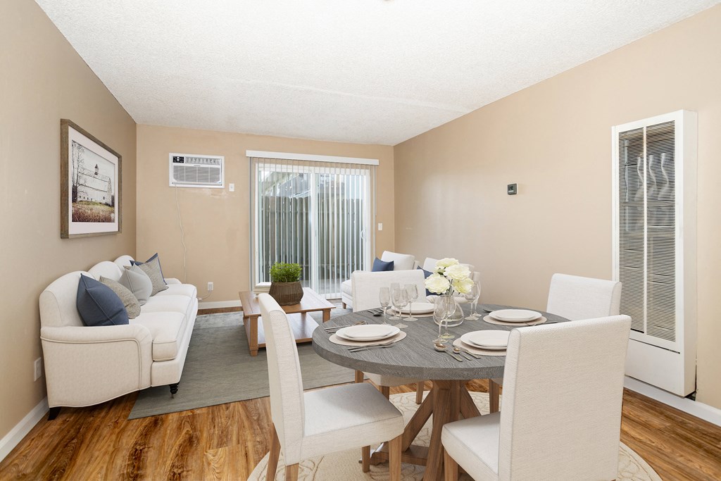 a living room and dining room with a table and chairs