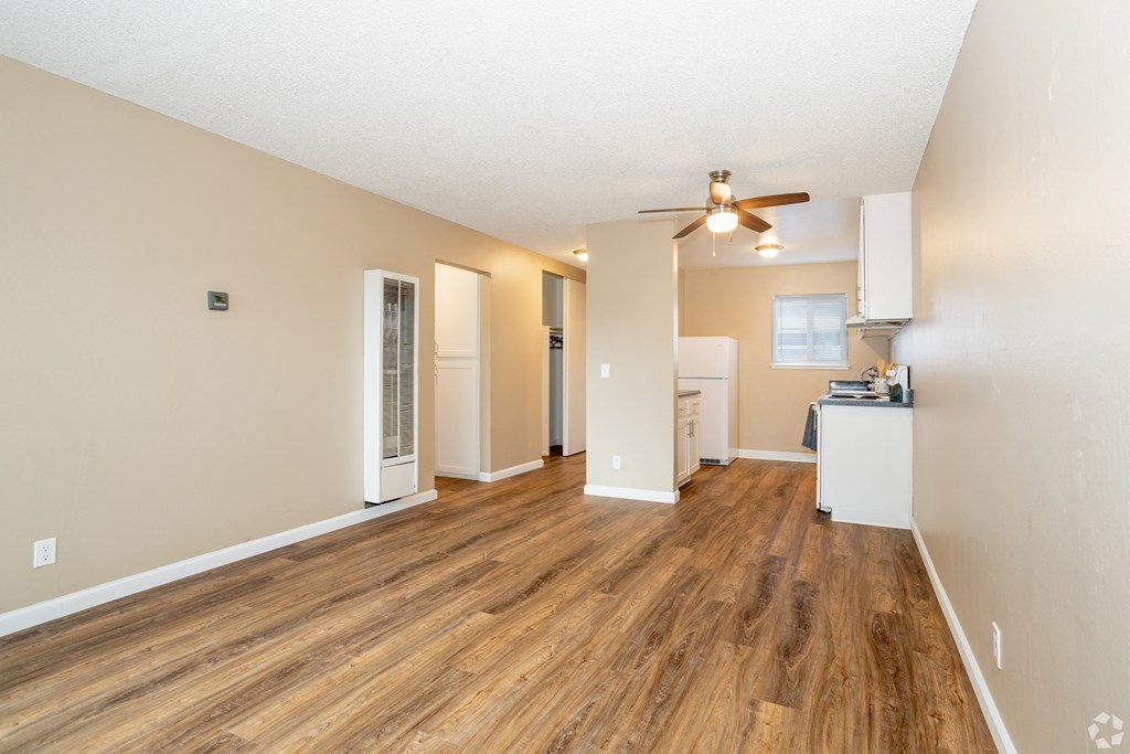 an empty living room with a ceiling fan and a kitchen at Ella 1711 Apartments, Woodland, CA 95695