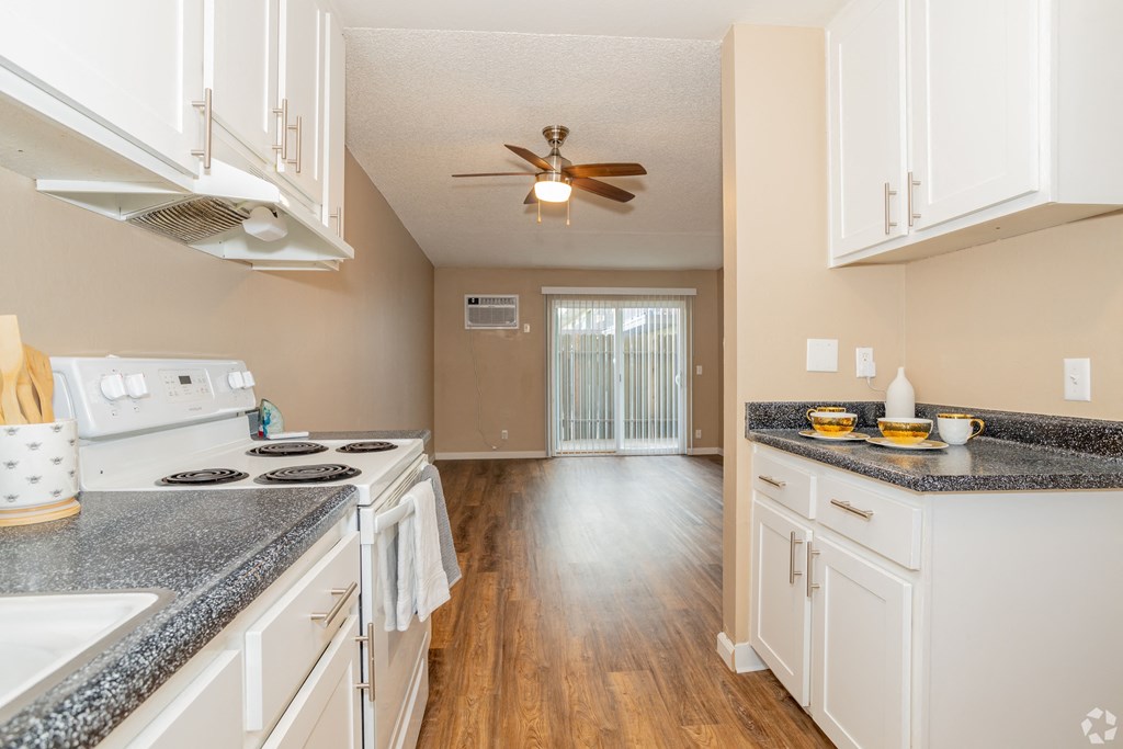an empty kitchen with white cabinets and a ceiling fan at Ella 1711 Apartments, Woodland, CA 95695