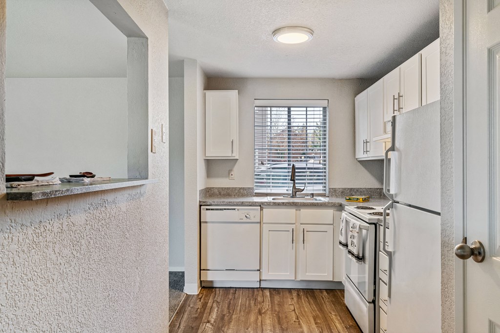 an open kitchen with white appliances and white cabinets