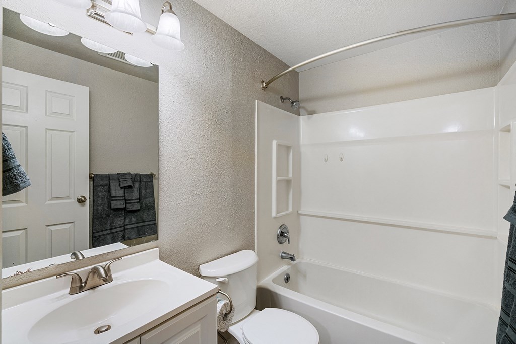 Bathroom with white counters, a mirror, sink, toilet, shower, and bath tub from left to right.at Capitol Crossing, Olympia, WA 98501