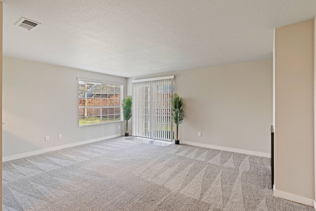 an empty living room with white walls and a window