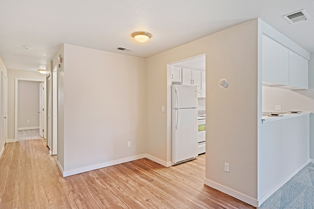 Wood floor hallway with laundry and linen closet leading to carpeted bedroom with kitchen on right side.at Capitol Crossing, Olympia, WA 98501