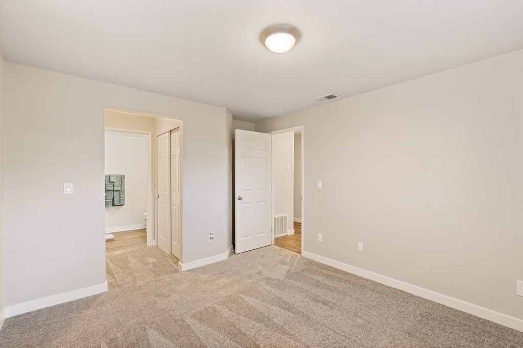 Bedroom with a hallway lined with closets to bathroom on left and door leading to rest of home on right.at Capitol Crossing, Olympia, 98501