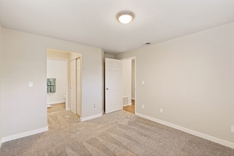 Bedroom with a hallway lined with closets to bathroom on left and door leading to rest of home on right.at Capitol Crossing, Olympia, 98501