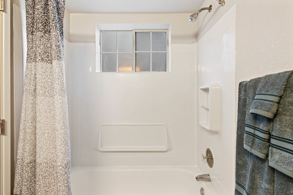 a small bathroom with a shower and a window