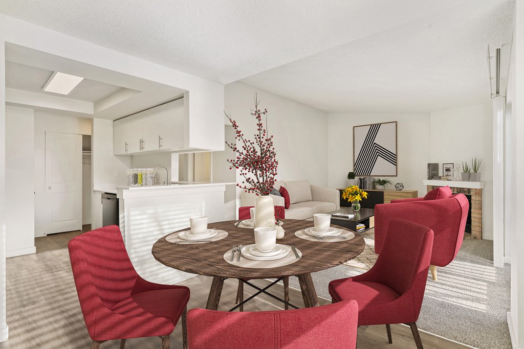 Dining area with white walls and the kitchen is to the left, and the living room is to the right. Staged with a round table and 4 red chairs. at Pointe East, Washington, 98424