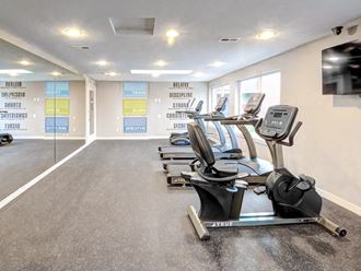 The fitness center has a flat screen TV, a sitting bike, two treadmills, and an elliptical in Fife, WA. - Photo Gallery 5