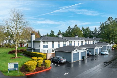 a view of the exterior of a building with cars parked in a parking lot