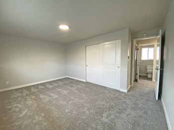 Carpeted bedroom, huge closet with sliding doors, door to the hallway, and bathroom. - Photo Gallery 12