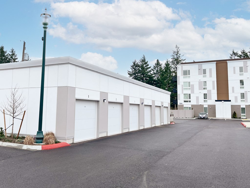 The Duo tenant garages with a parking lot in front of them at The Duo, University Place, 98466