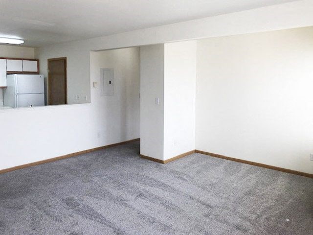 A room with a grey carpet and white walls.