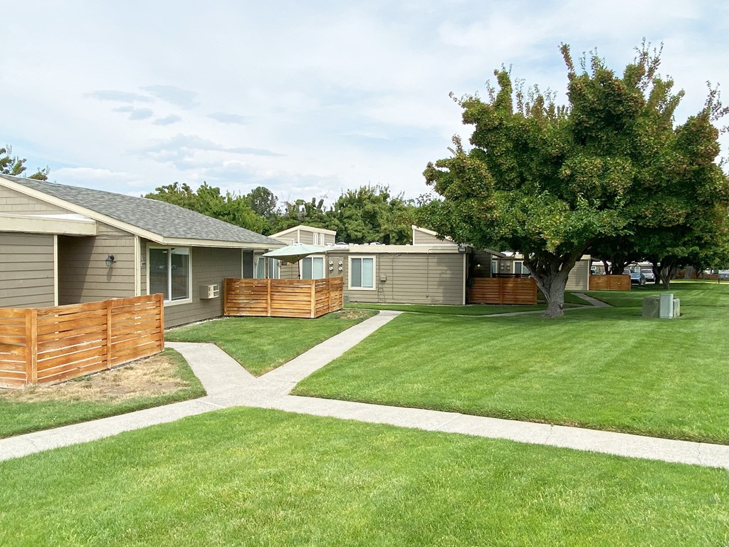 Green grass pathway leading to private homes at Park View Apartments in Wenatchee, WA