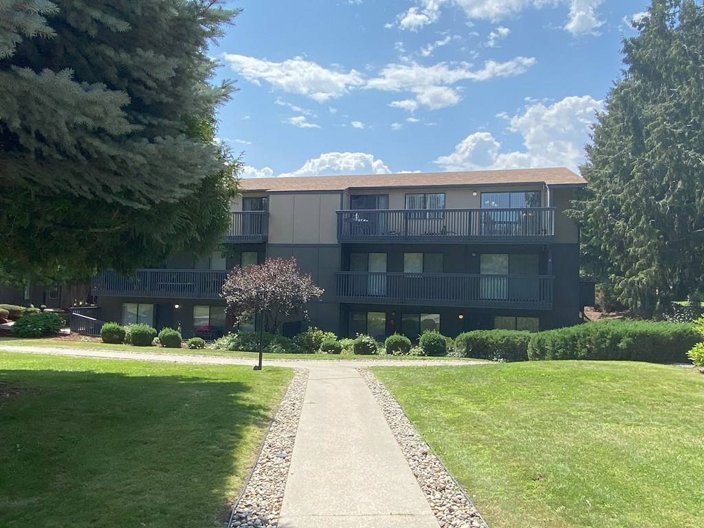 a large building with a brown roof and a sidewalk leading to it at Cedarwood, Washington, 98801