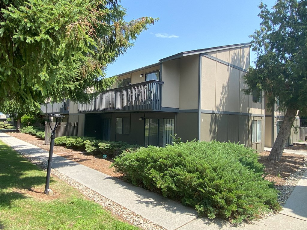 a building with a balcony and a sidewalk in front of it at Cedarwood, Washington
