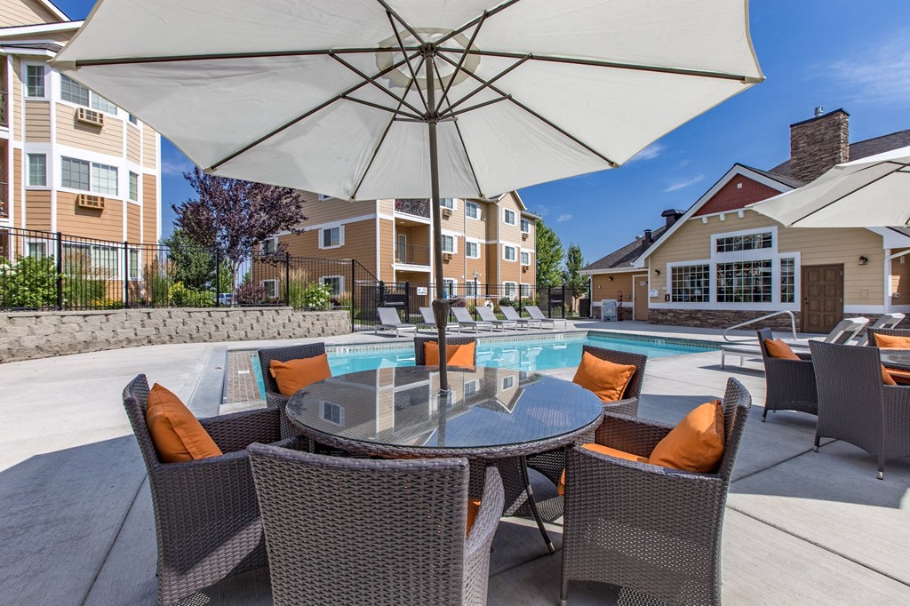 our apartments have a large pool and patio with chairs and umbrellas. Poolside lounge area