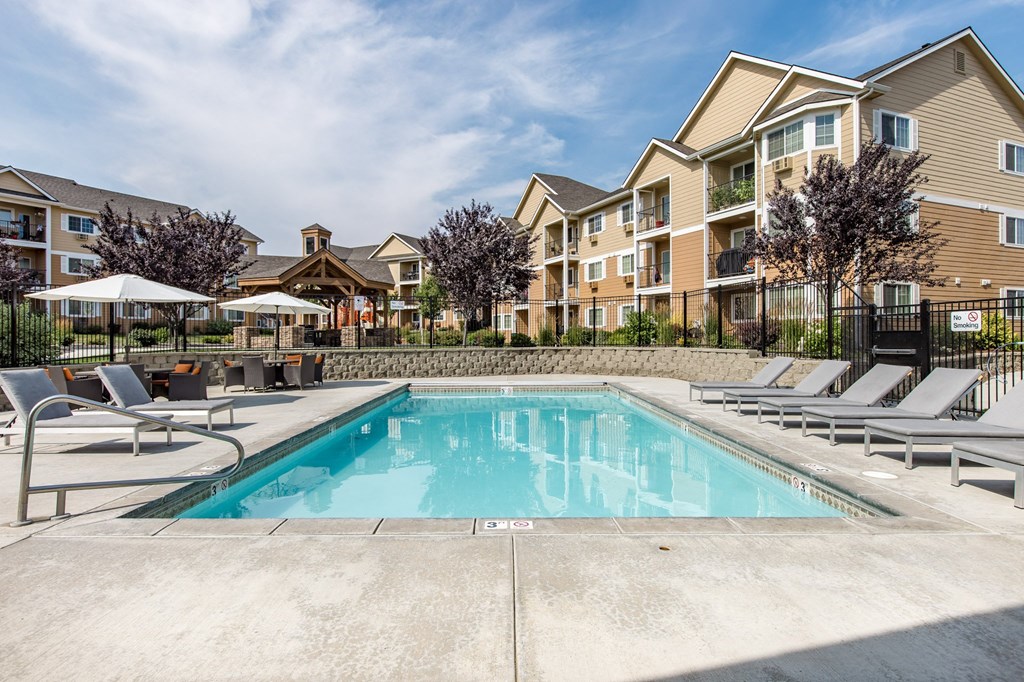 our apartments have a swimming pool with chairs and umbrellas. apartments with a pool at Quail Springs Apartments
