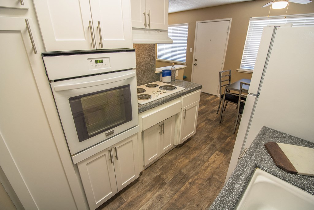 kitchen with new white cabinets and gray faux granite countertops, with dining area visible in the distance at Woodland Village Apartments , California, 95695