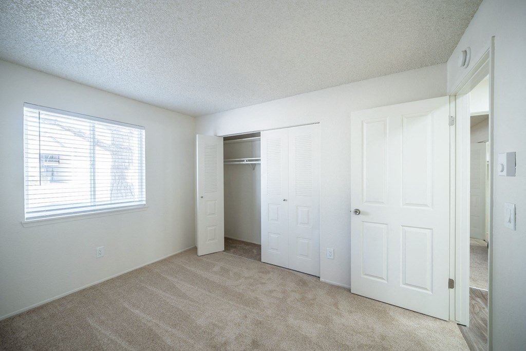 an empty bedroom with a closet and a window at Kirkwood in Pocatello, ID