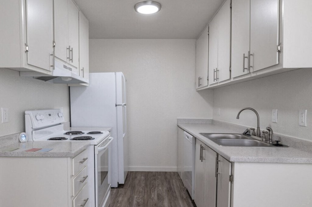 a kitchen with white cabinets and a sink and a refrigerator at Kirkwood Meadows, Pocatello, ID 83201