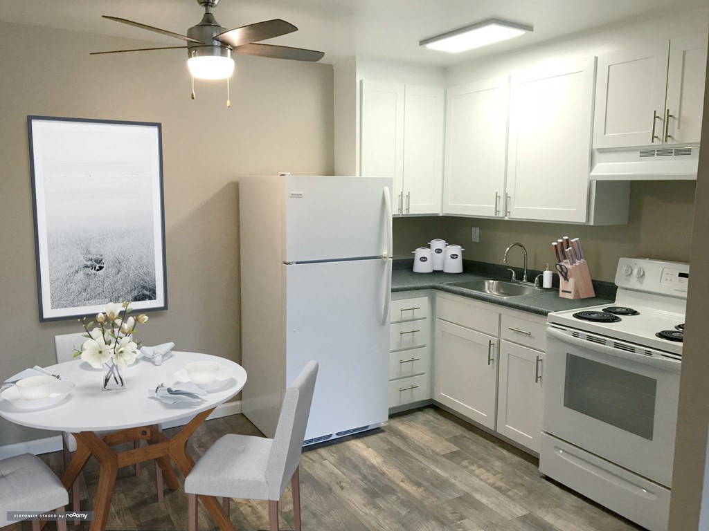 a small kitchen with white appliances and a white table and chairs at Woodland Crossing , Woodland California