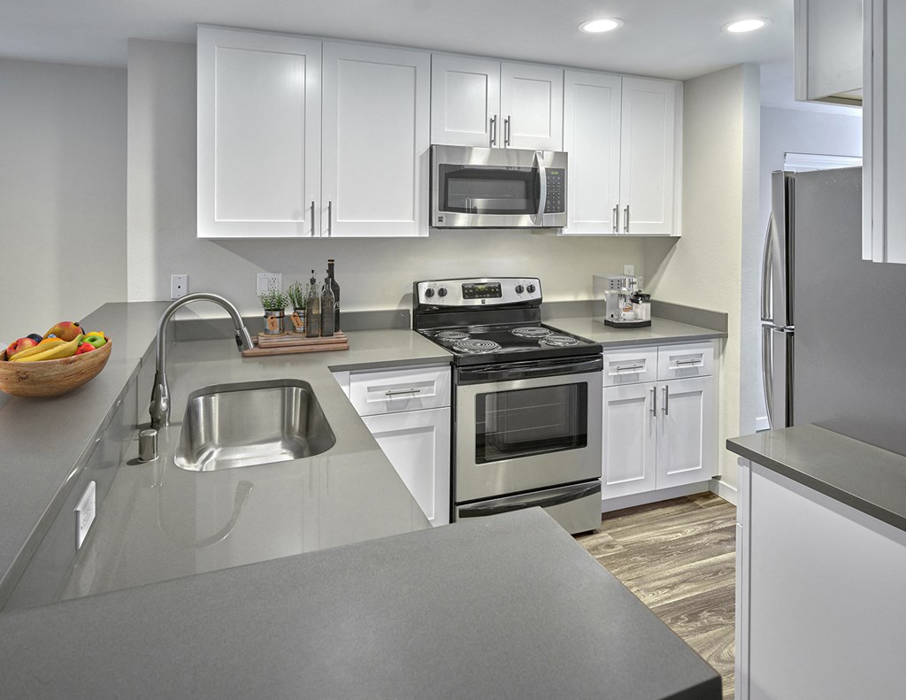 Updated kitchen with stainless steel appliances, white cabinets, and grey countertops.at Edmonds Gateway, Edmonds Washington