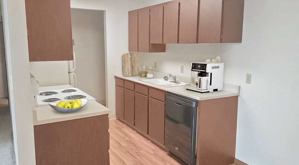 Double galley kitchen, top and bottom cabinet storage, sink, dishwasher, stove top, staged with coffee machine, fruit bowl.at Laurel Park, Twin Falls, 83301