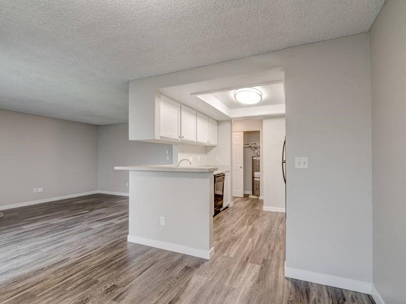 A dining area looks into the kitchen and living room with wood flooring and lots of natural light. at Pointe East, Washington