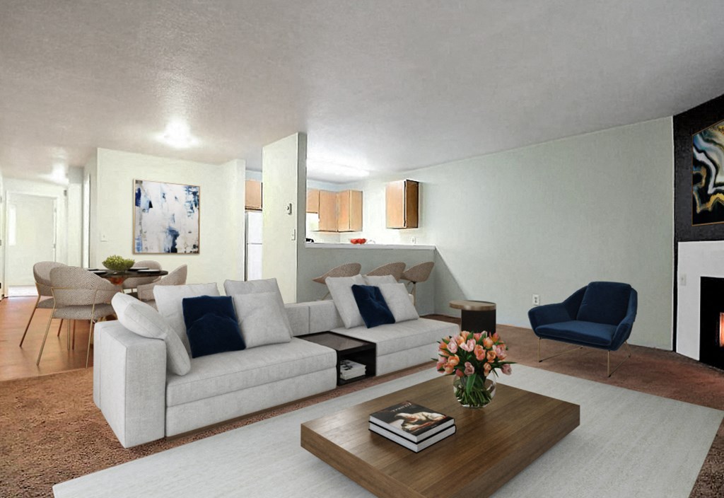 Living Area with large sofa, coffee table and chair. Living area looks into kitchen over a half wall.at Capitol Crossing, Olympia, WA