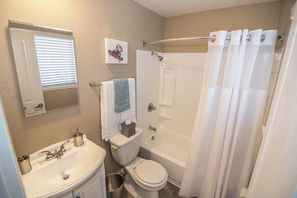 Master Bathroom with white fixtures, large bathtub and window at Woodland Village Apartments , Woodland California