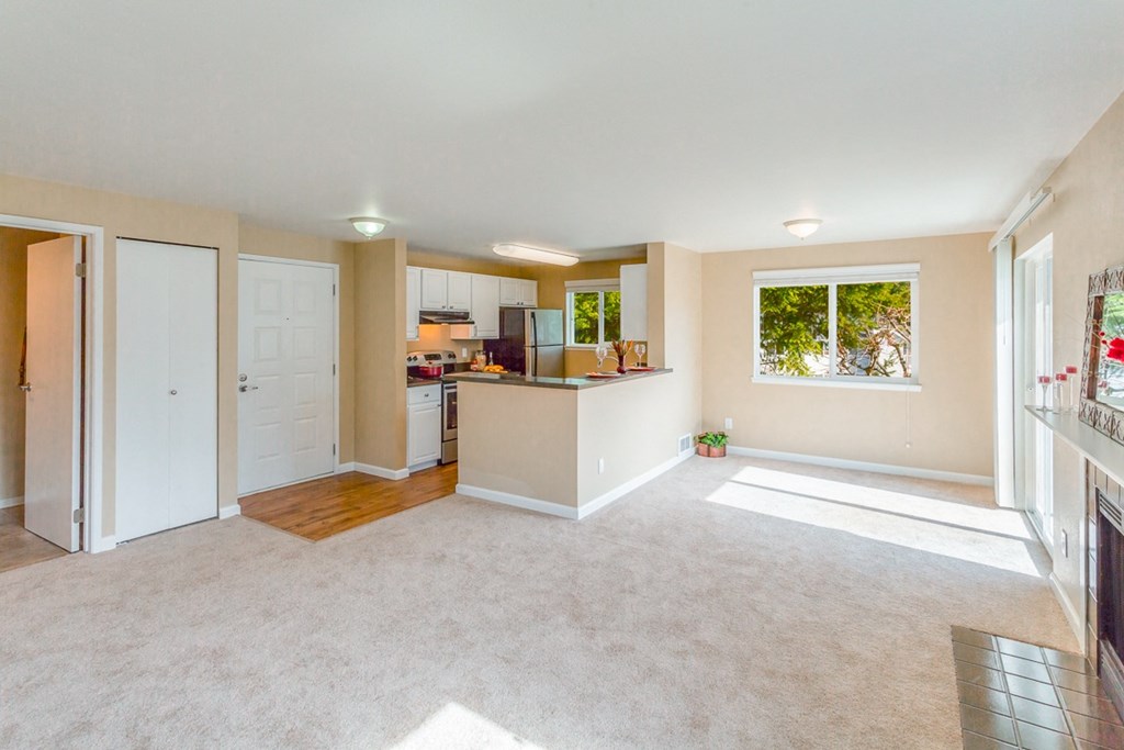 an empty living room with a kitchen and a window at Springfield, Renton