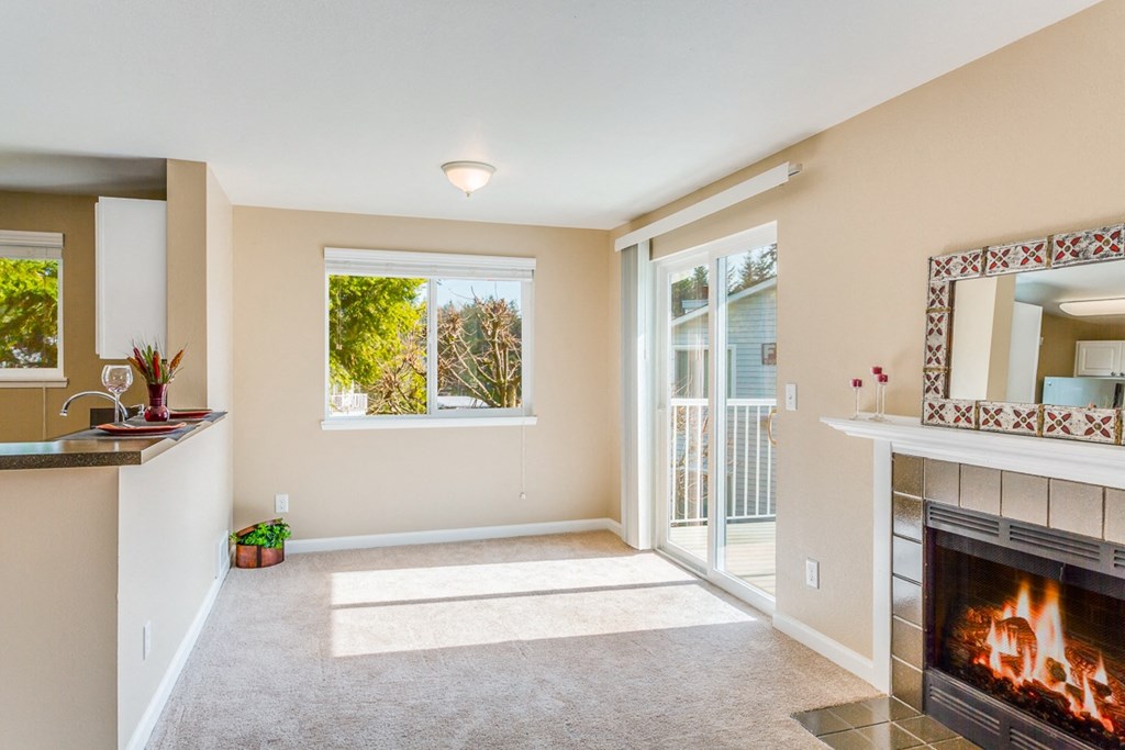 an empty living room with a fireplace and a balcony  at Springfield, Renton, WA