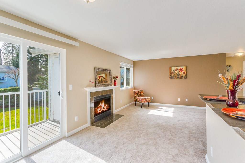 a living room with a fireplace and a balcony at Springfield, Renton, WA 98055