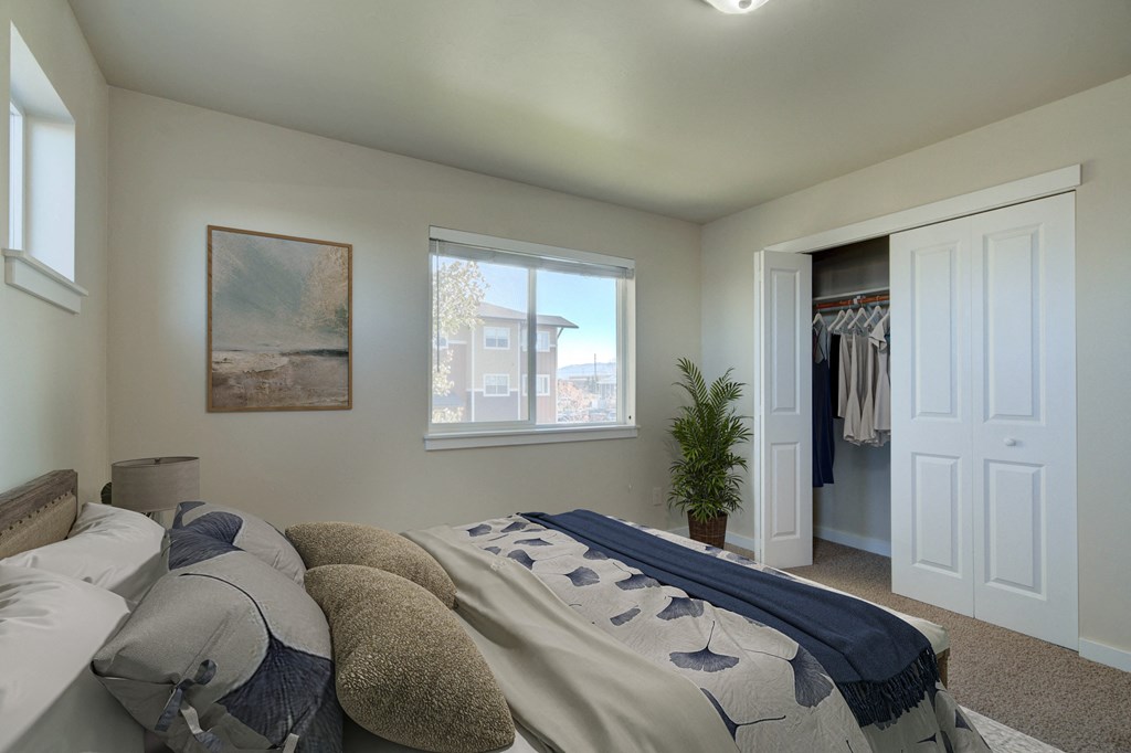a bedroom with a bed and a closet with a window  at Madison Park, Bozeman, 59718