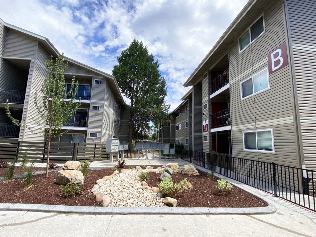 an outdoor area with rocks and plants in front of an apartment building  at Talavera, Boise, Idaho