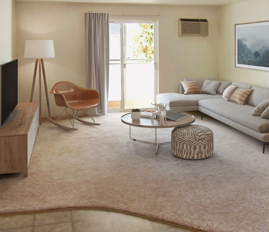 North Pointe living room with light gray carpet, sliding glass doors to patio and staged with couch, coffee table, TV, chair.at North Pointe, Post Falls, ID