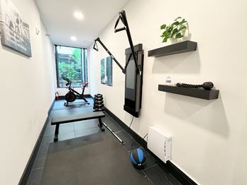 a home gym with a treadmill and a tv on the wall  at Oslo, Seattle, 98102